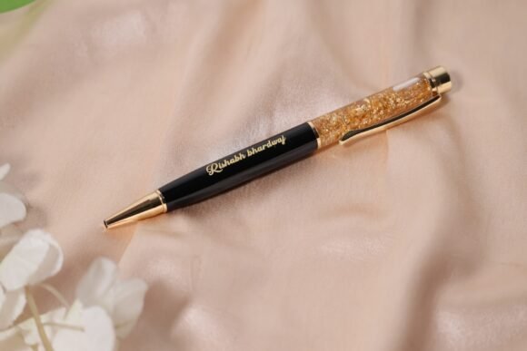 Personalized black and gold metal pen with gold flakes, name engraved, soft grip, medium point, and blue ink – elegant gift for professionals or personal use.